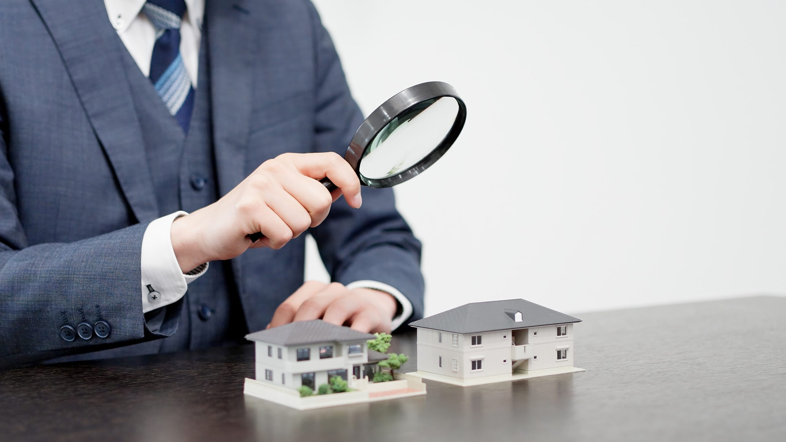 Businessman inspecting a house with a magnifying glass